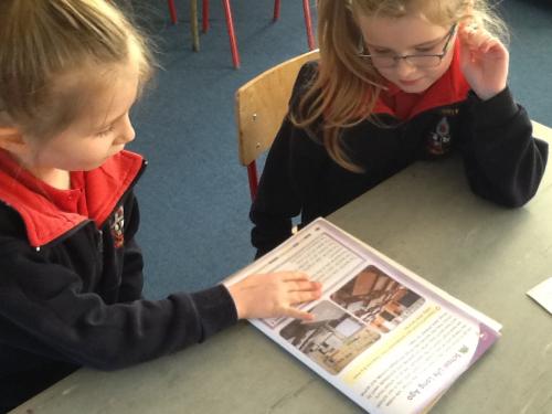 Two pupils work together on a reading task 